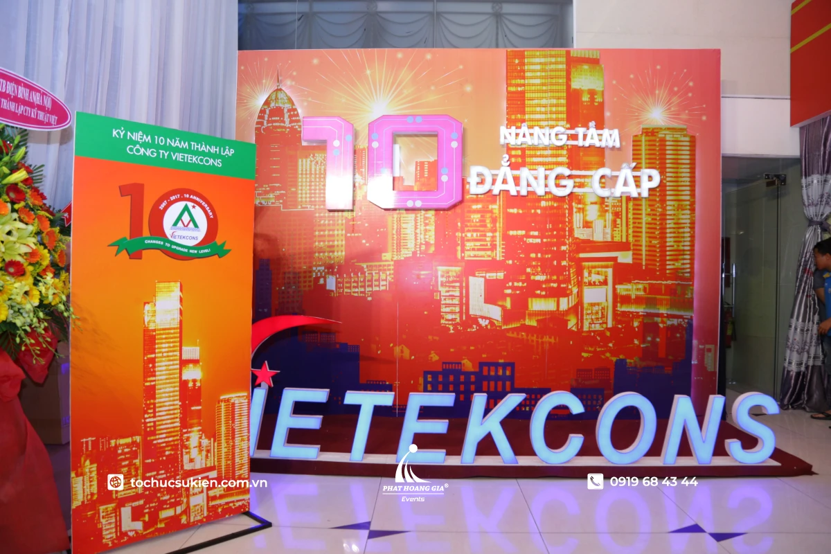 Backdrop chụp hình với chi tiết 3D và đèn trang trí cho khu vực check-in tại lễ kỷ niệm.