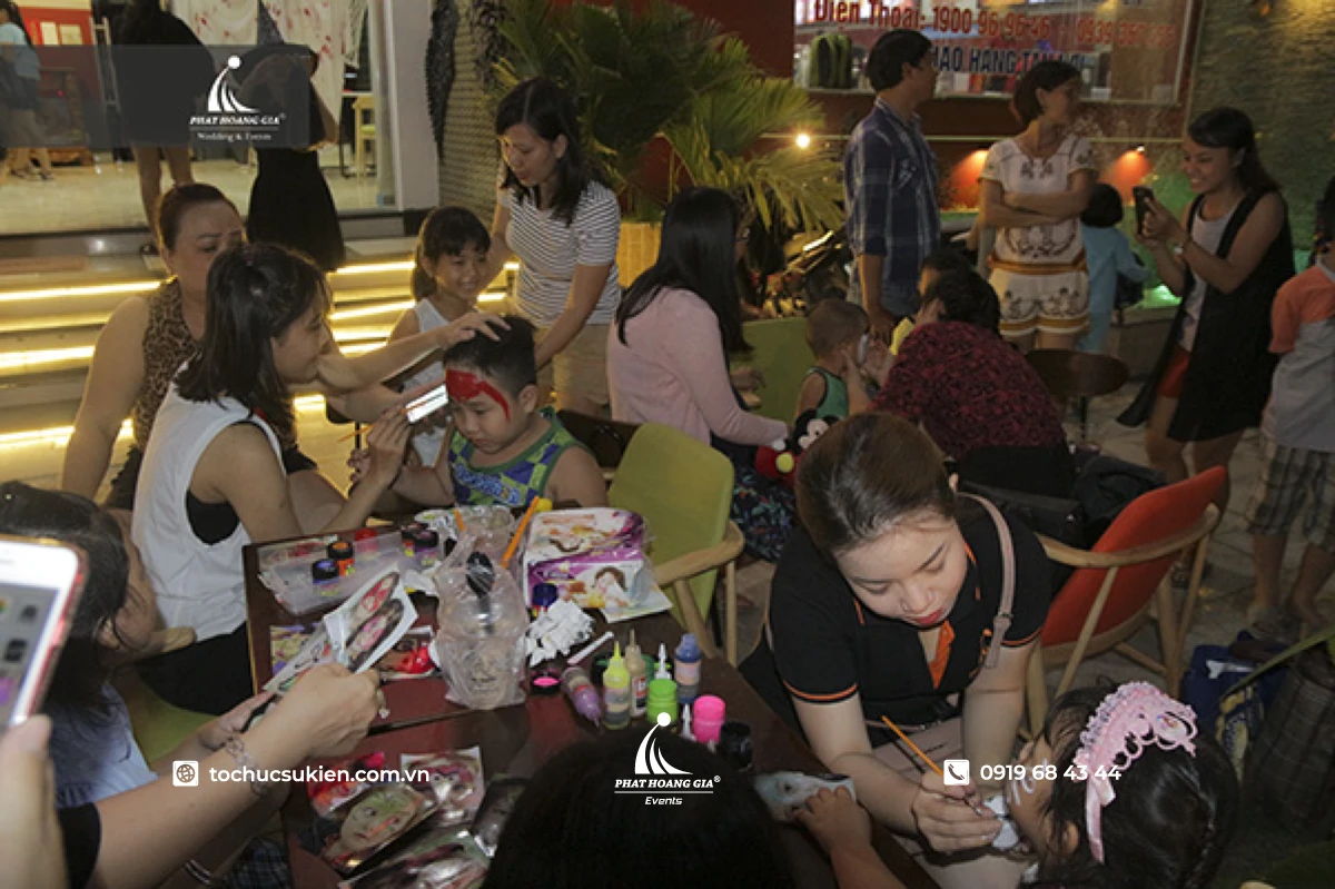 khung cảnh các bạn nhỏ hào hứng vẽ mặt hóa trang để tìm hiểu halloween là ngày gì trong sự kiện đêm hội