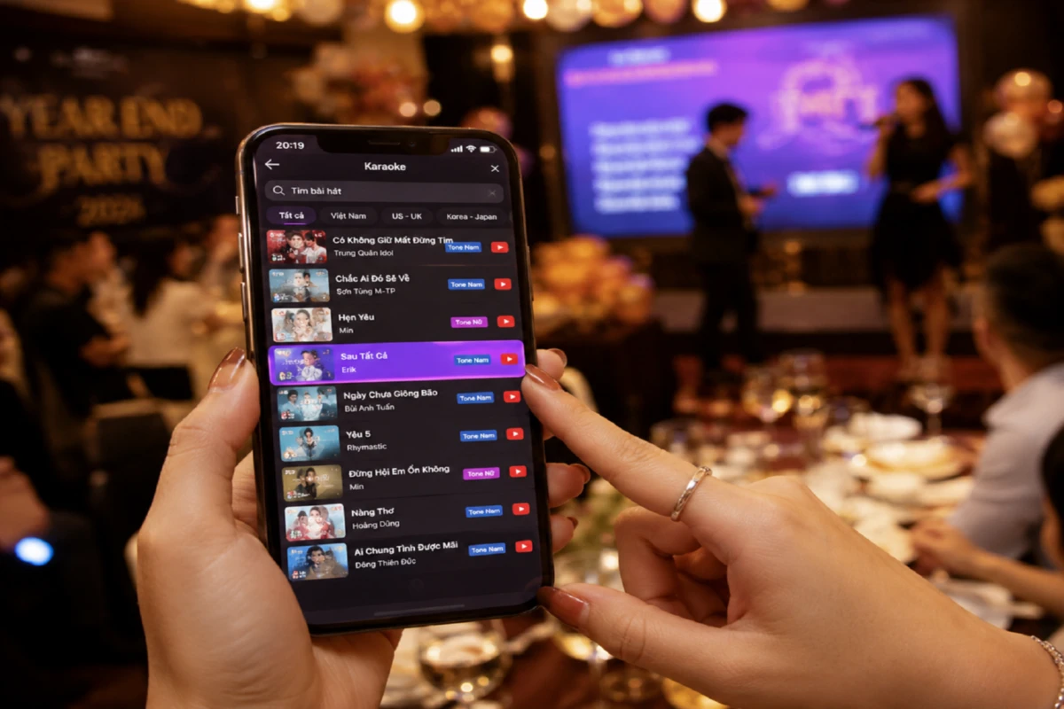 Người dùng xem danh sách bài karaoke trên điện thoại để chọn bài phù hợp khi tham gia tiệc công ty