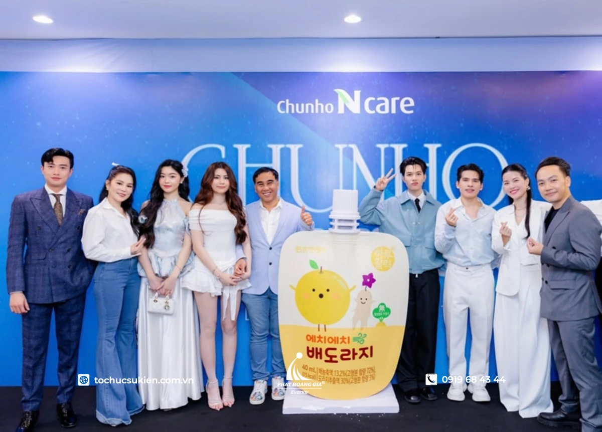 KOL và khách mời check-in tại launch event nước trái cây trước backdrop thương hiệu