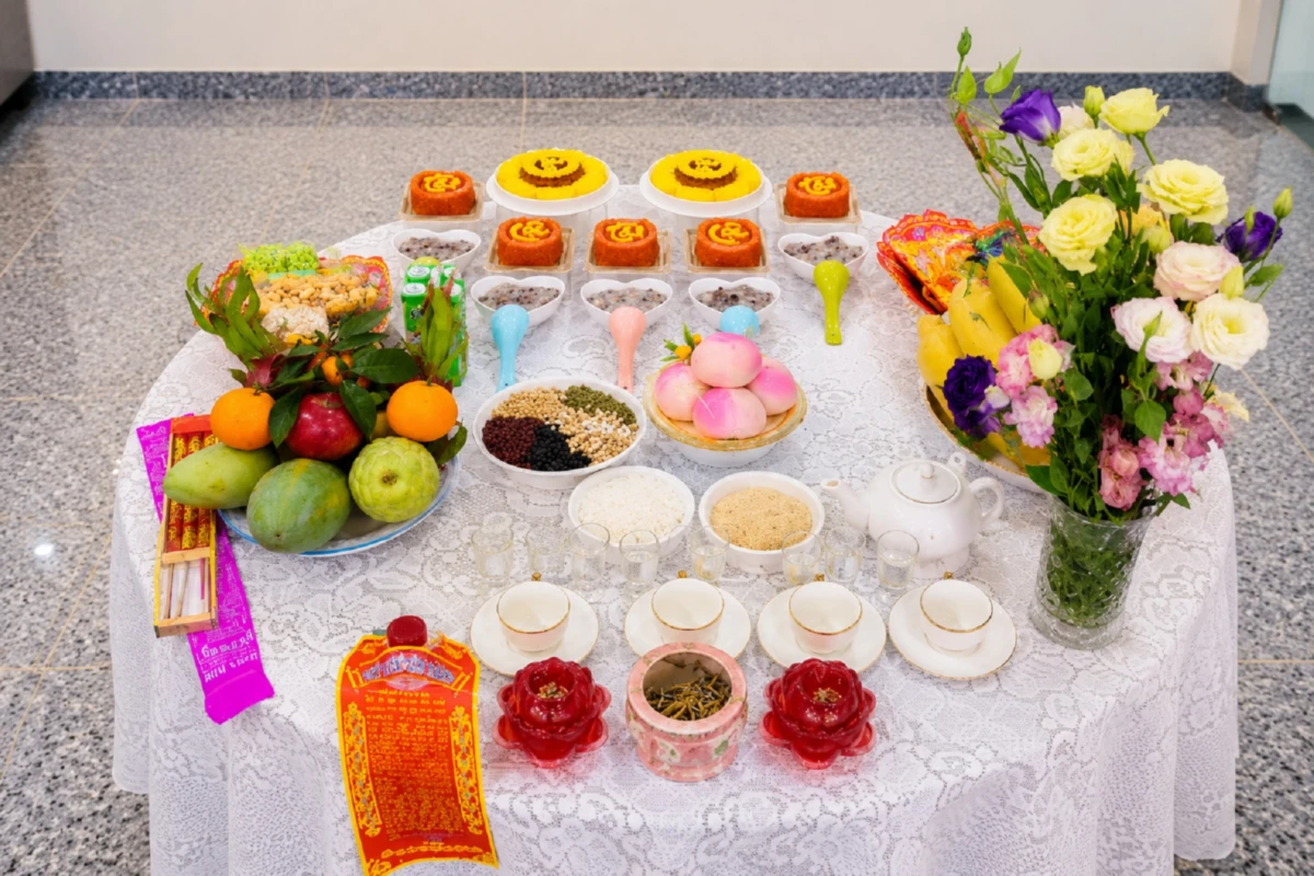 Mâm cúng khai trương chay với lễ vật thuần chay, trái cây, bánh, trà và hoa tươi được bày trên bàn tròn