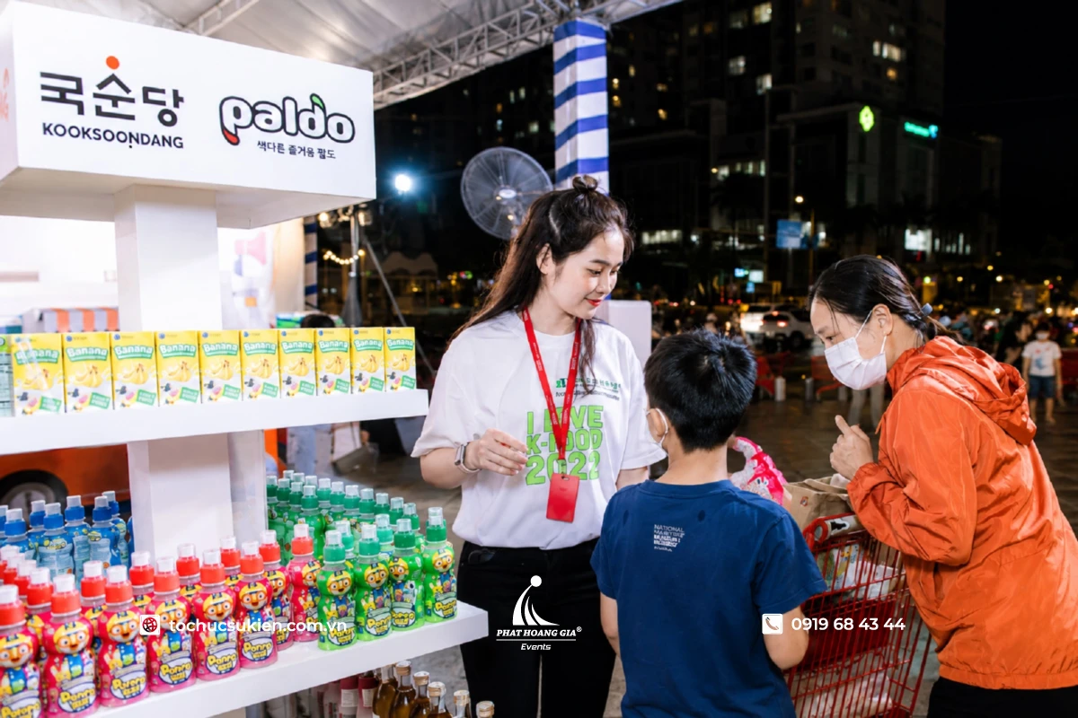 Hoạt động sampling phát mẫu dùng thử sản phẩm cho khách hàng tại booth sự kiện ngoài trời, minh họa sampling là làm gì