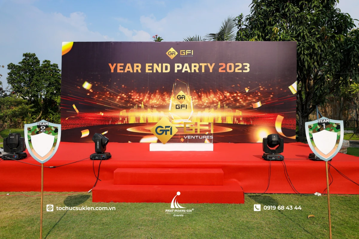Sân khấu ngoài trời cho tiệc year end party doanh nghiệp với backdrop lớn, thảm đỏ và hệ thống ánh sáng sự kiện