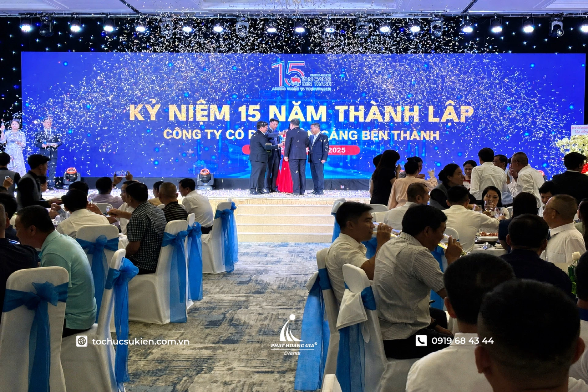 Concept gala kỷ niệm thành lập doanh nghiệp với sân khấu LED xanh và hiệu ứng pháo giấy nghi thức khai mạc
