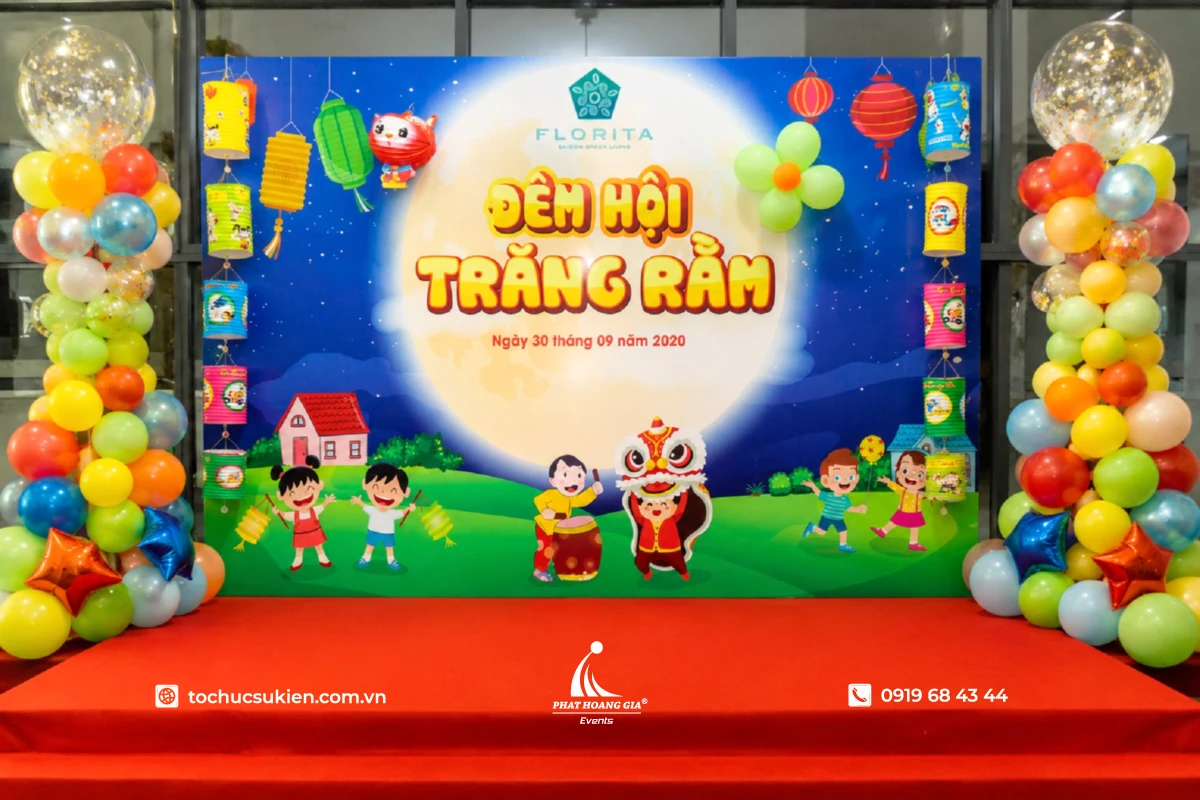Sân khấu trung thu được trang trí với bóng bay nhiều màu, backdrop trăng rằm và đèn lồng trang trí trong nhà