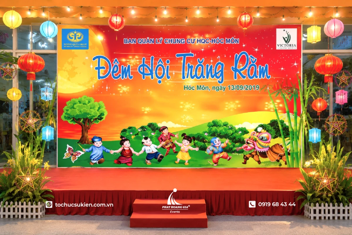 Sân khấu Trung Thu được trang trí với backdrop trăng rằm rực rỡ, đèn lồng và lồng đèn ông sao trong không gian sự kiện thiếu nhi