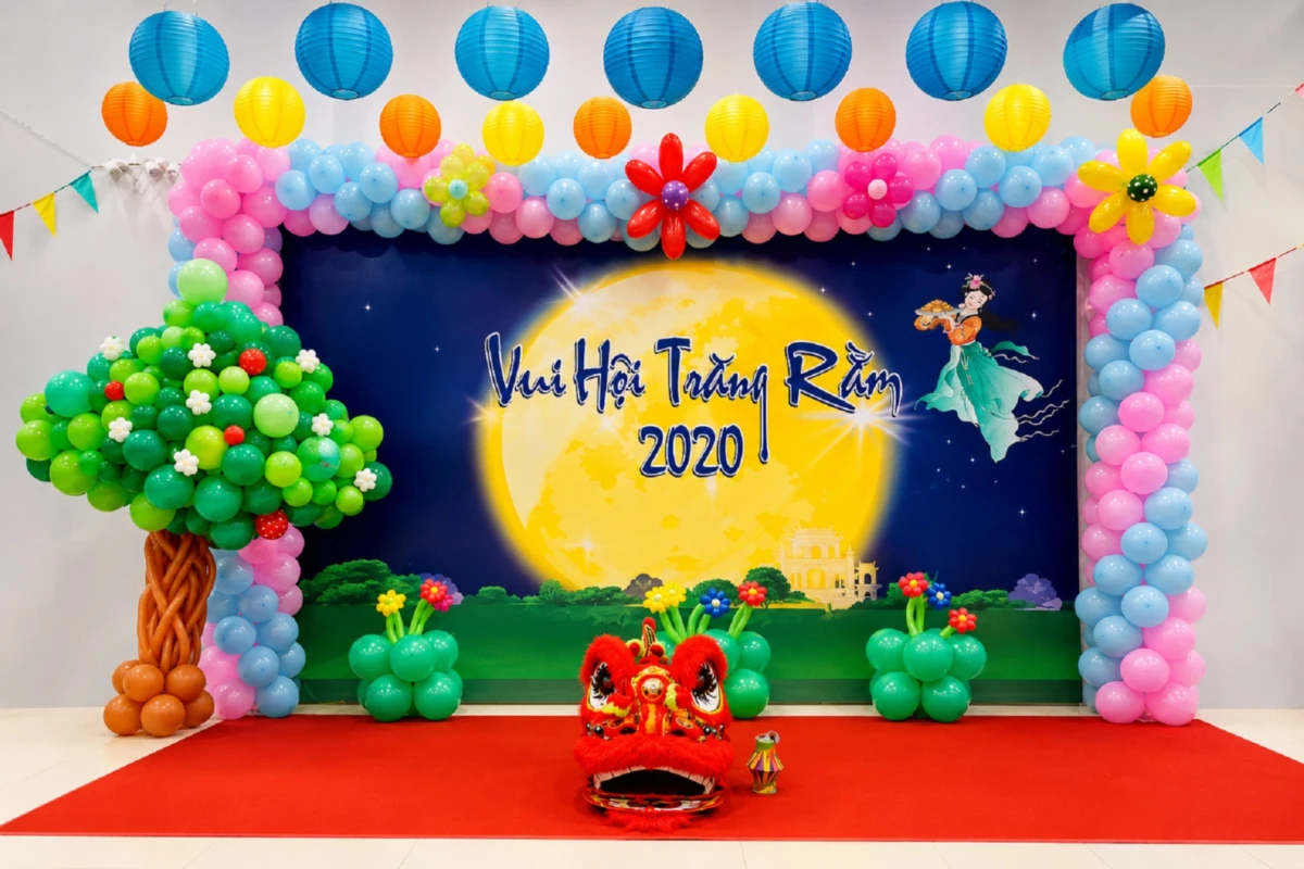 sân khấu trung thu trong nhà với backdrop trăng rằm, bóng bay nhiều màu và đèn lồng treo trang trí