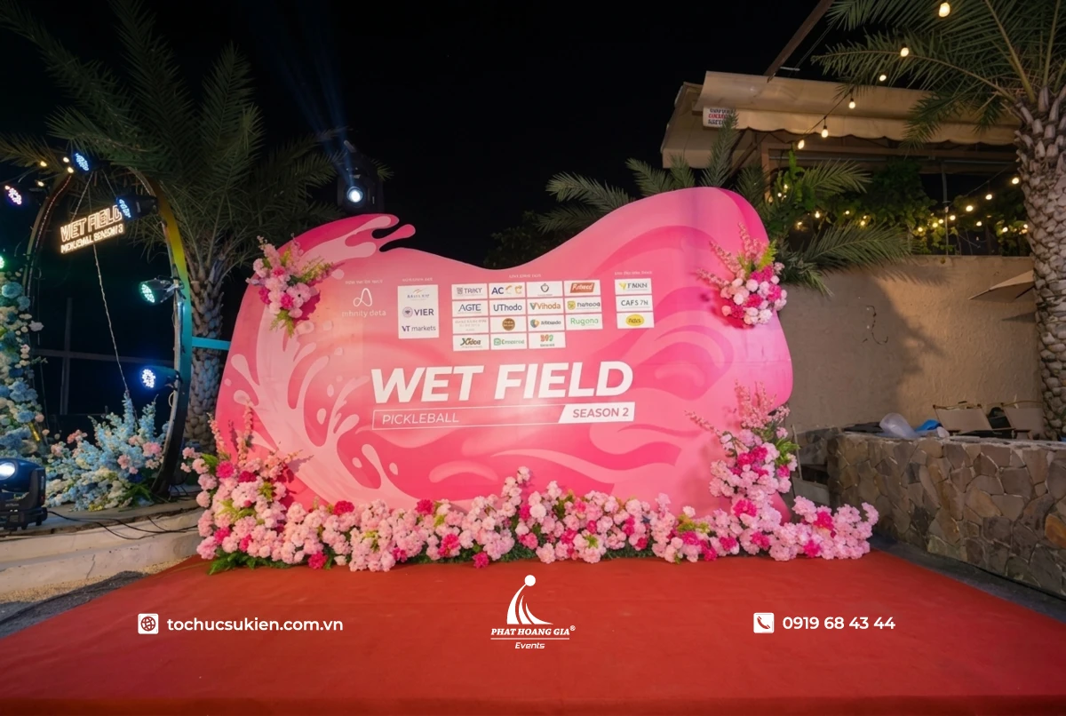 Backdrop gala dinner công ty trang trí viền hoa tươi tone hồng trắng hoàn thiện bắt mắt