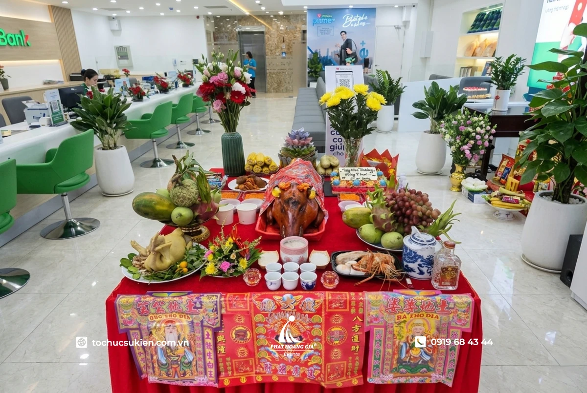 Bàn cúng khai trương với mâm lễ đầy đủ heo quay gà luộc xôi chè trong sảnh công ty trang trọng