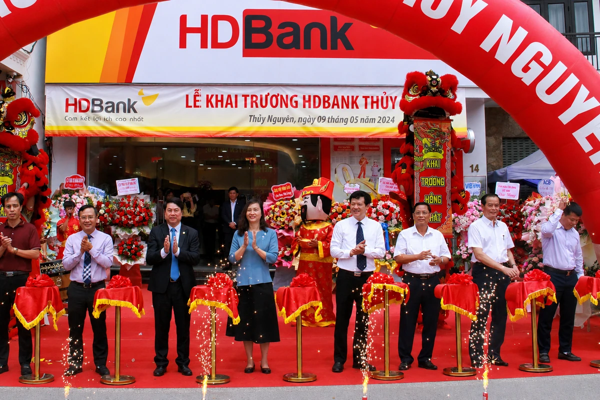 Nghi thức cắt băng khai trương diễn ra trước cửa hàng với cổng hơi và băng rôn trang trí nổi bật, tạo không khí sự kiện chuyên nghiệp