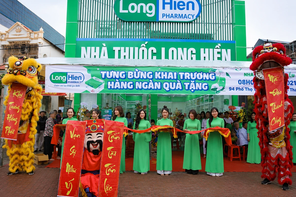 Băng rôn khai trương được treo trước cửa hàng trong không gian chuẩn bị cho lễ cắt băng khánh thành cùng đội ngũ PG