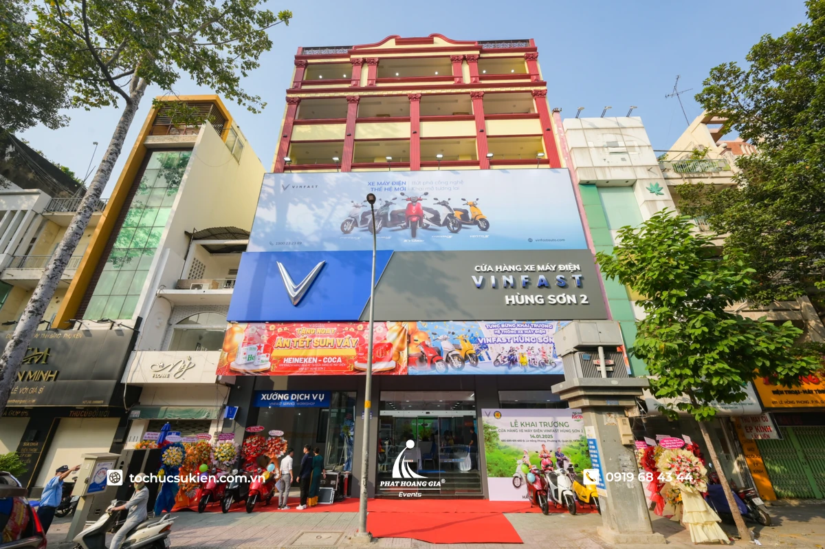 Cửa hàng VinFast rực rỡ với các dải banner khai trương treo tại mặt tiền cùng thảm đỏ và hoa chúc mừng.