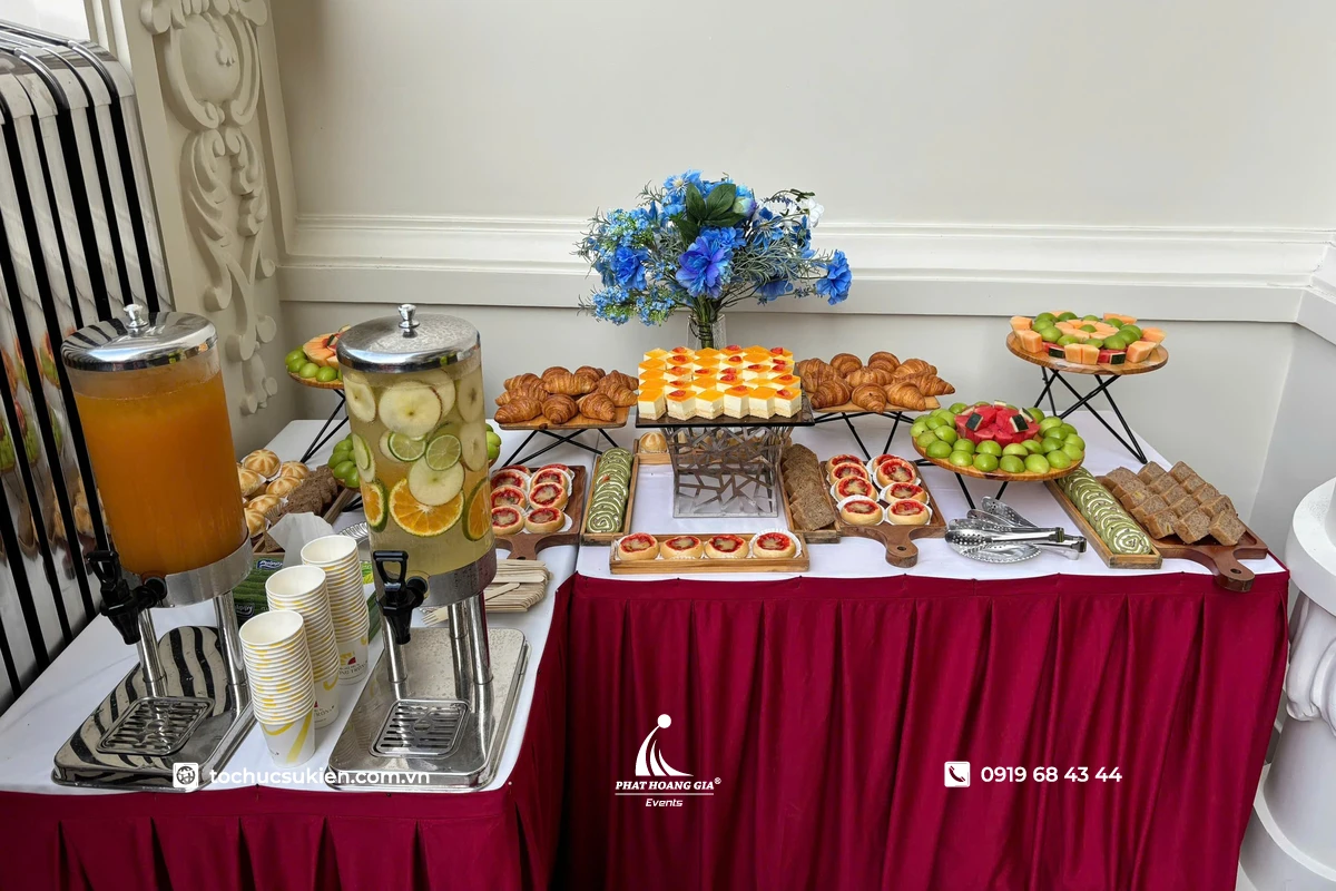 Bàn tiệc tea break đầy đủ với bánh ngọt, trái cây, nước uống và cách bày trí sang trọng, chuyên nghiệp