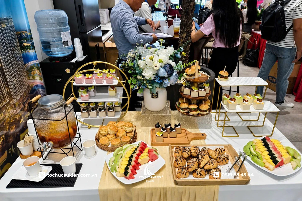 Bàn tiệc trà với bánh ngọt theo tầng cùng các loại trái cây và nước uống được bày trí đẹp mắt trong không gian sang trọng