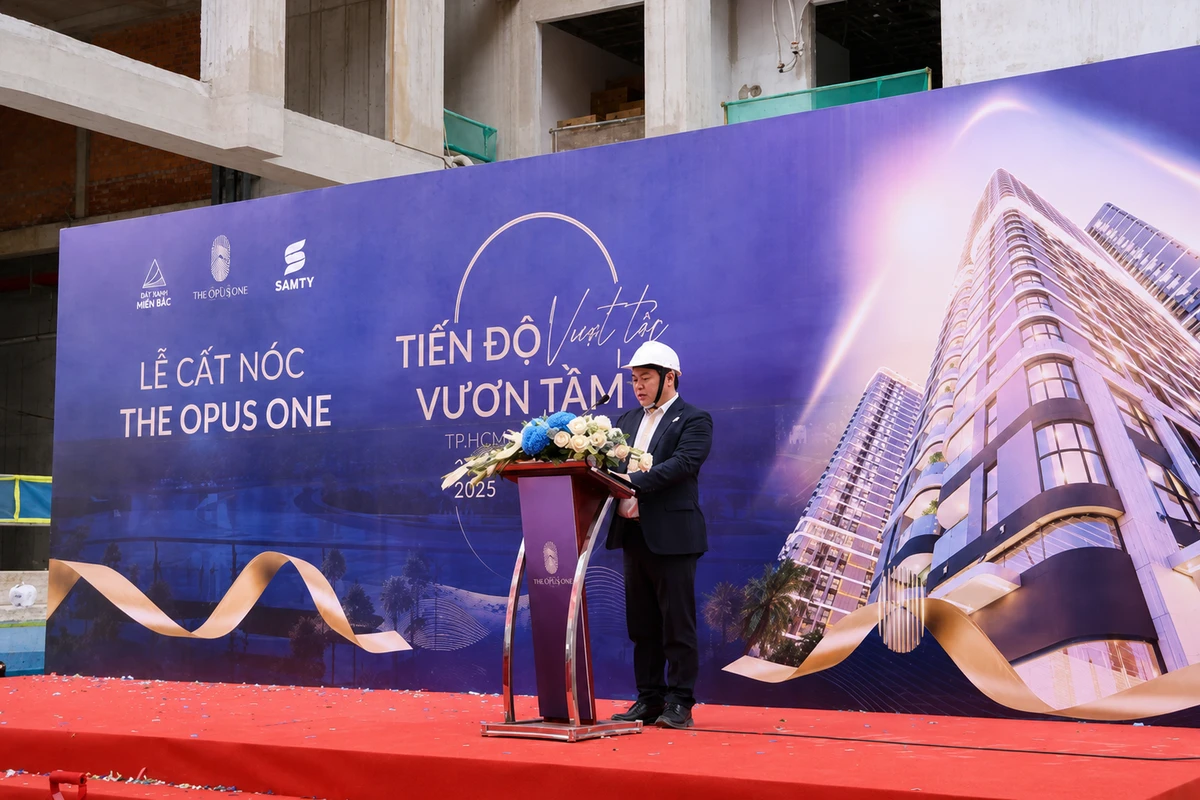 Đại diện dự án phát biểu trên sân khấu với backdrop lễ cất nóc được thiết kế và thi công chuyên nghiệp