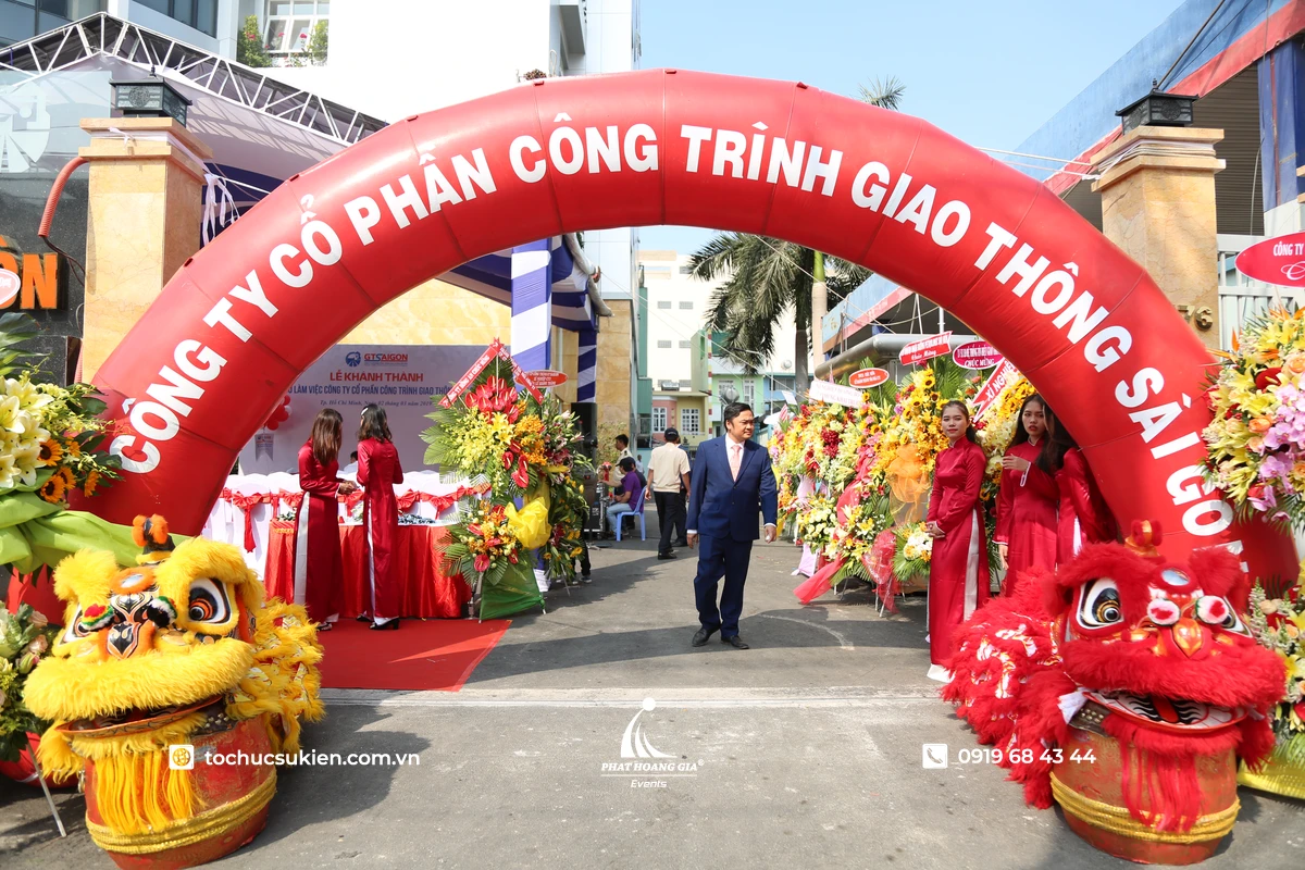 Cổng hơi màu đỏ nổi bật được bố trí tại lối vào sự kiện khai trương, kết hợp đầu lân trang trí hai bên và lối đi được thiết kế đẹp mắt, tạo điểm nhấn thu hút khách mời