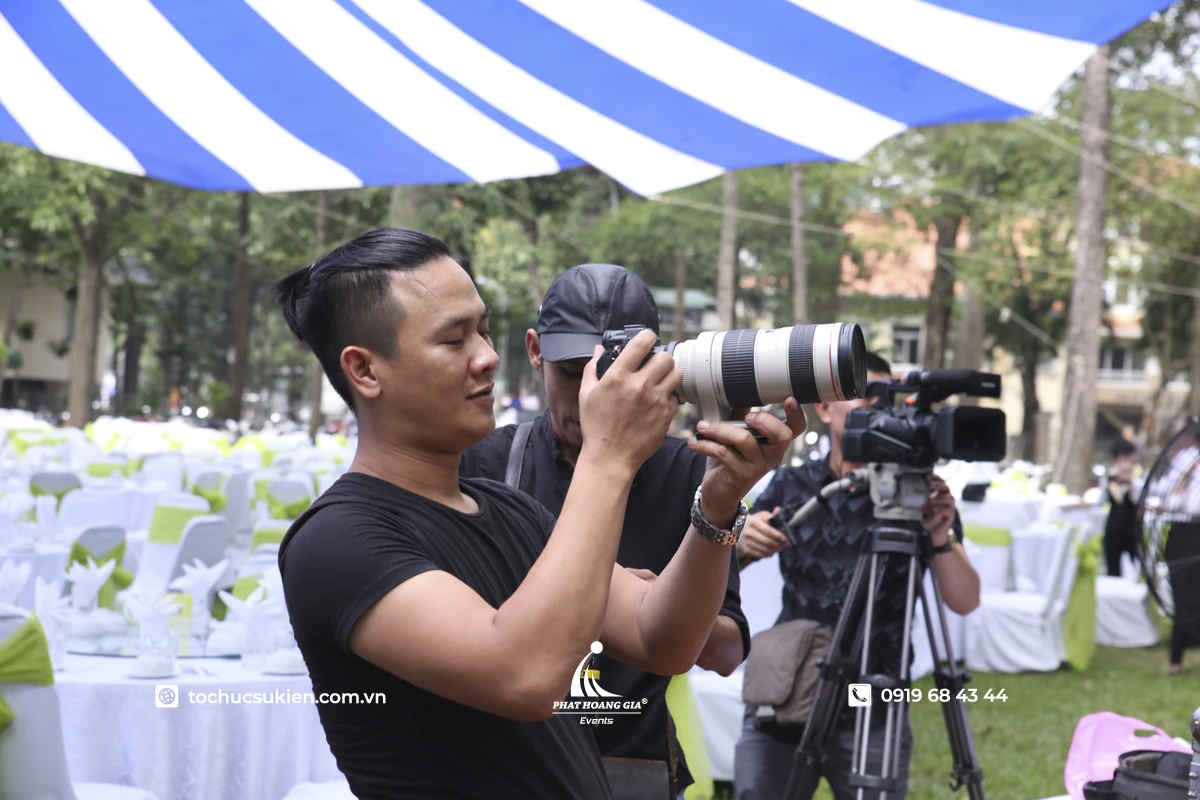 Chụp phóng sự sự kiện với photographer đang tập trung quan sát để ghi lại những khoảnh khắc tự nhiên và cảm xúc chân thật của khách mời