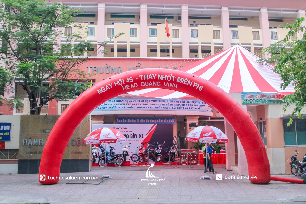 Cổng chào sự kiện bơm hơi màu đỏ được đặt ngay lối vào trường học, nổi bật với thông điệp chương trình và khu vực trưng bày phía bên trong
