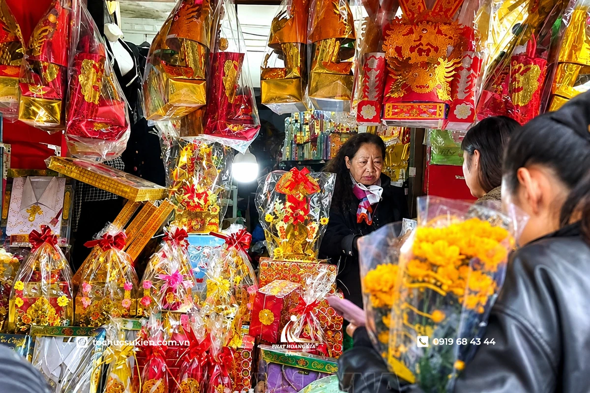 Khách hàng đang lựa chọn đồ cúng và hoa tươi tại khu chợ vàng mã nổi tiếng, nơi bày bán đa dạng các vật phẩm phục vụ lễ cúng và tâm linh