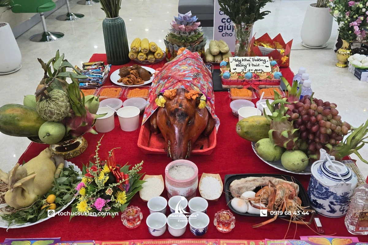 Mâm cúng khai trương đầu năm 2027 được chuẩn bị đầy đủ với heo quay, mâm ngũ quả, hoa tươi, nhang đèn