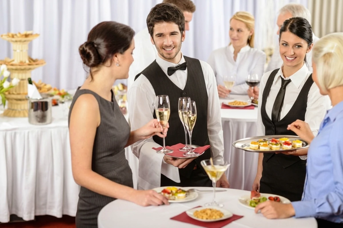 Nhân viên phục vụ rượu vang và bánh khai vị cho khách mời tại buổi tiệc teabreak sang trọng.