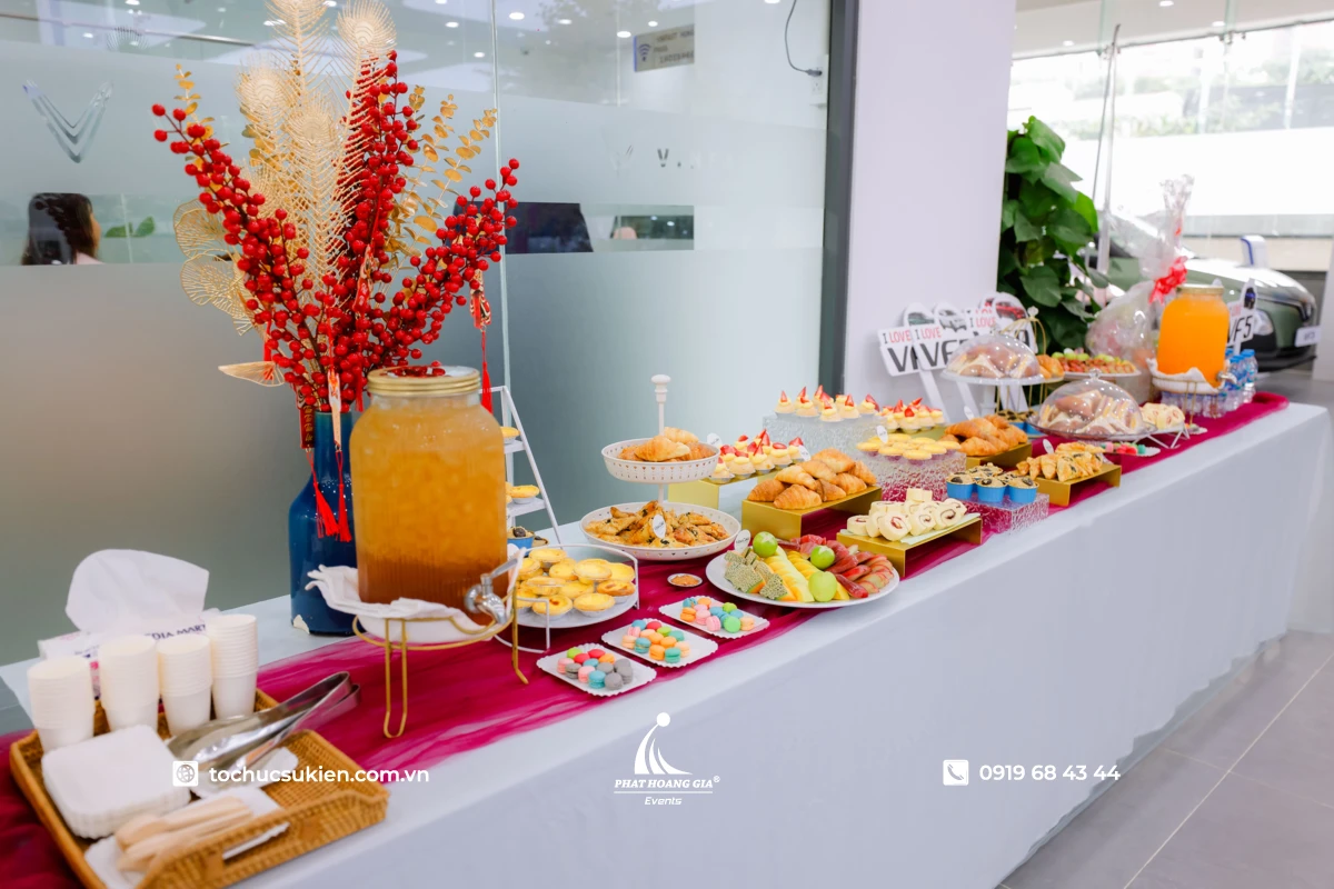 Bàn tiệc teabreak với nhiều loại bánh ngọt bánh mặn trái cây và đồ uống được bày biện đẹp mắt