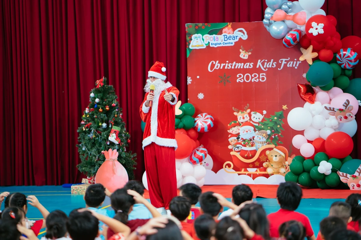 Người hóa trang ông già noel đang giao lưu và chia sẻ kiến thức với các em nhỏ trong chương trình Giáng sinh tại trường học với không khí vui tươi và ấm áp