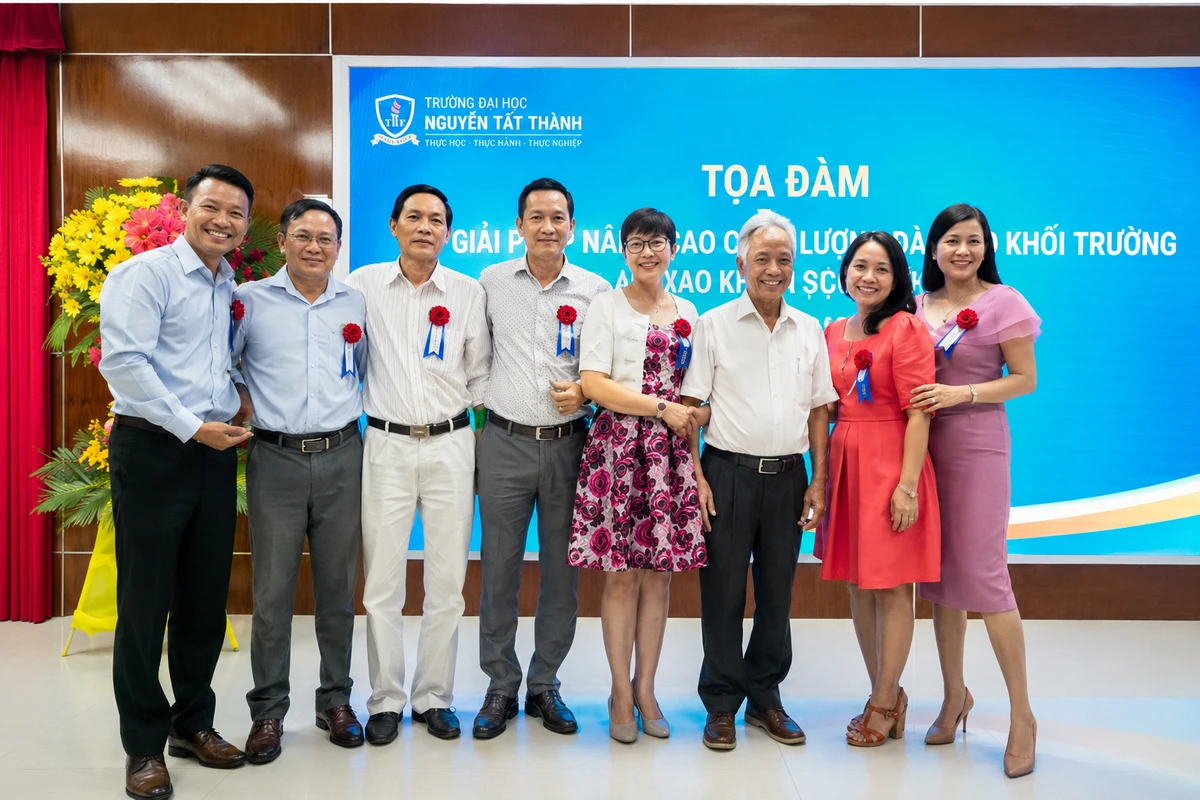 Các đại biểu chụp ảnh lưu niệm trên sân khấu hội nghị với hoa cài áo đại biểu nổi bật trong buổi tọa đàm trang trọng