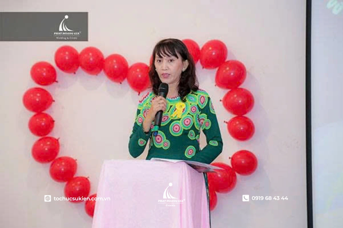 Kế hoạch tổ chức 8/3 tại trường học trang trọng với hình ảnh cô hiệu trưởng phát biểu trên sân khấu
