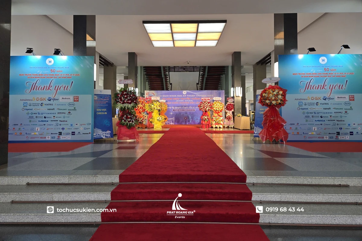 Khu vực đón tiếp bên ngoài hội nghị với thảm đỏ dẫn vào backdrop sự kiện được thiết kế chỉn chu và sang trọng