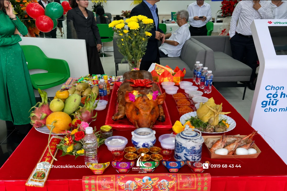 Mâm cúng khai trương cửa hàng đầy đủ với heo quay gà luộc hoa quả vàng mã bày biện trang trọng