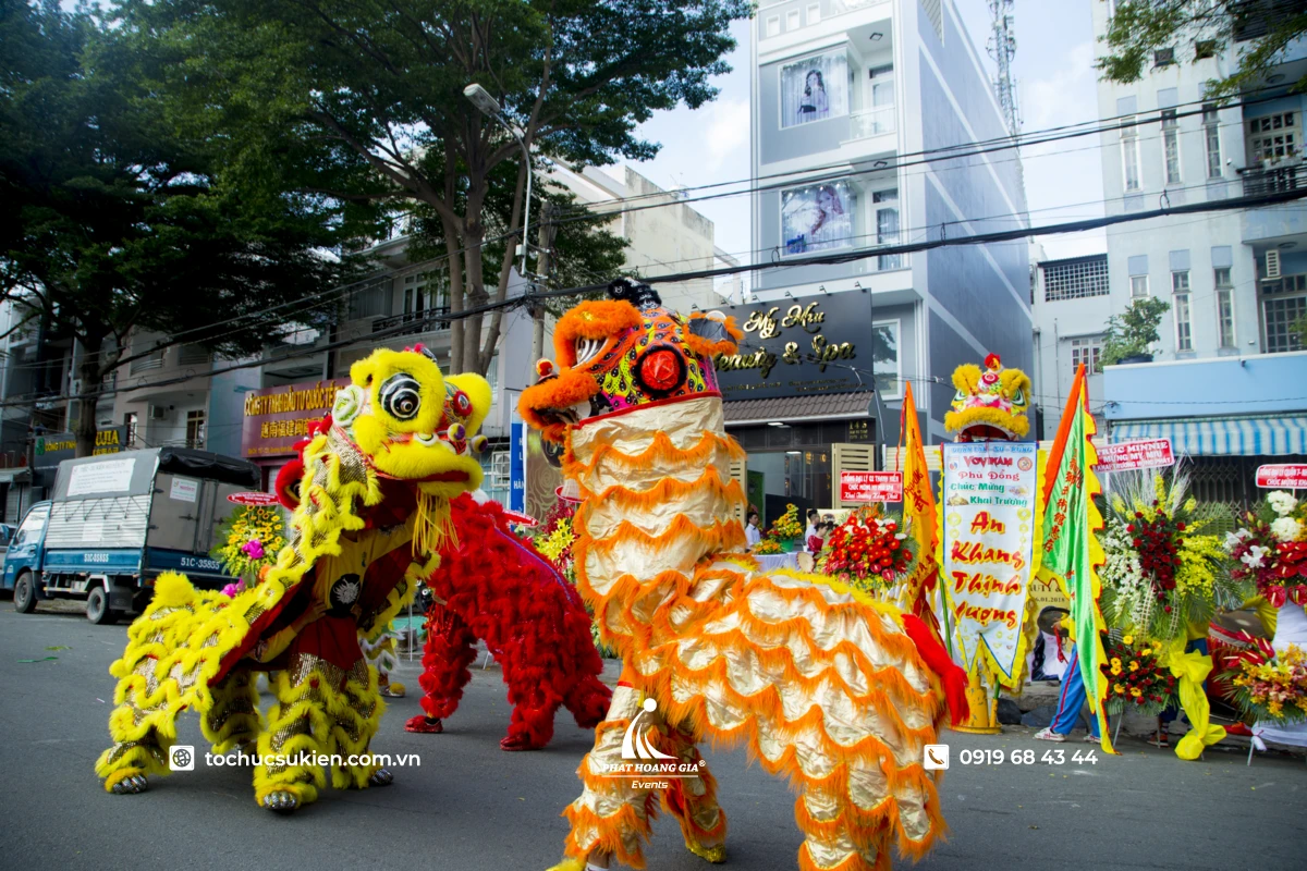 Không khí náo nhiệt của buổi lễ khai trương với sự xuất hiện của đoàn múa lân và lẵng hoa chúc mừng.