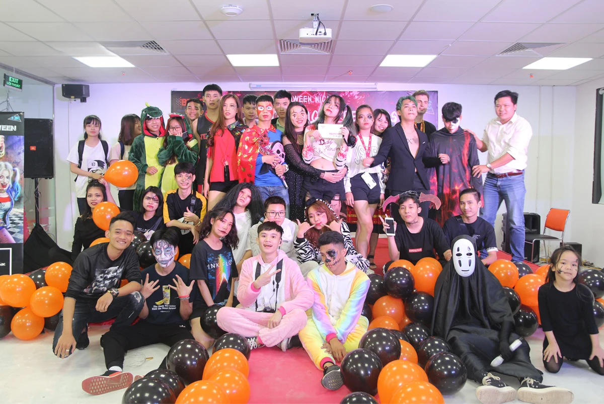 Tập thể người tham gia đứng ngồi tạo dáng chụp ảnh lưu niệm trong lễ hội hóa trang Halloween.