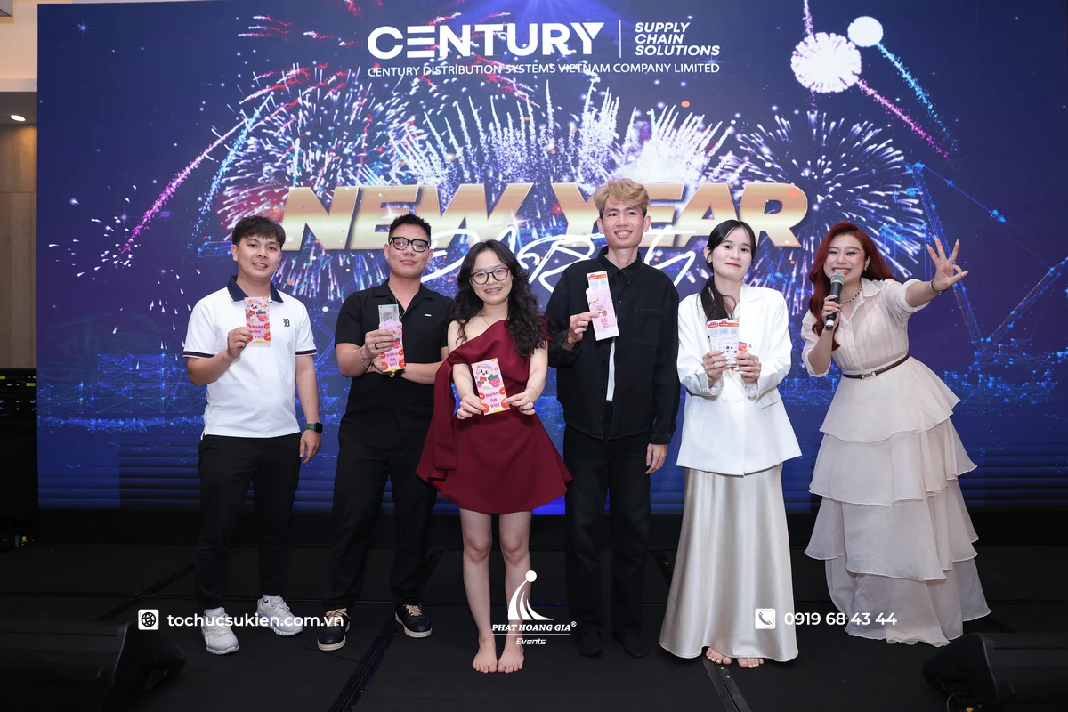 MC nữ trao quà cho nhân viên trong không khí vui tươi tại chương trình chào đón năm mới
