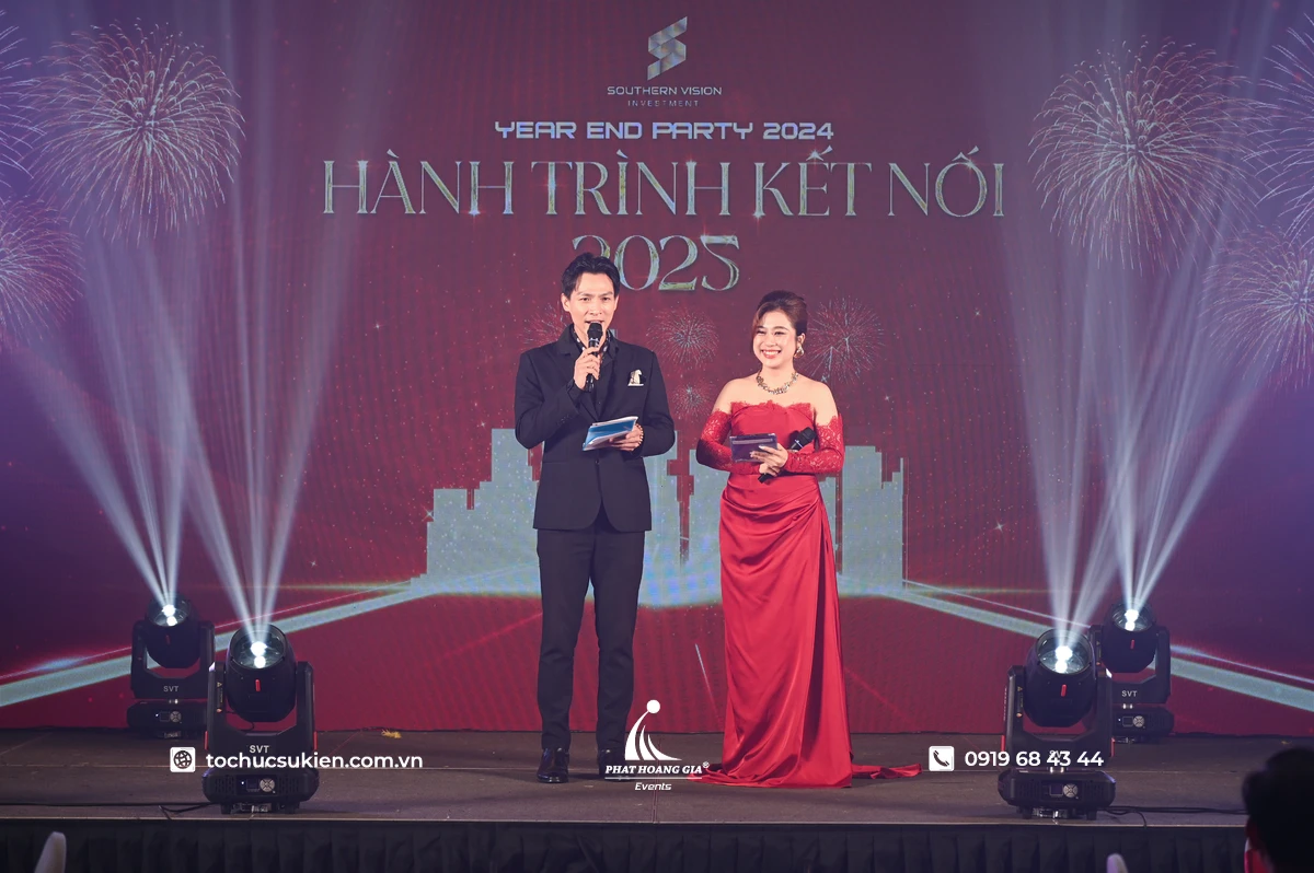 Cặp đôi MC nam nữ trong trang phục nổi bật dẫn đang đọc lời dẫn chương trình lễ hội mùa xuân được tổ chức vào đầu năm mới