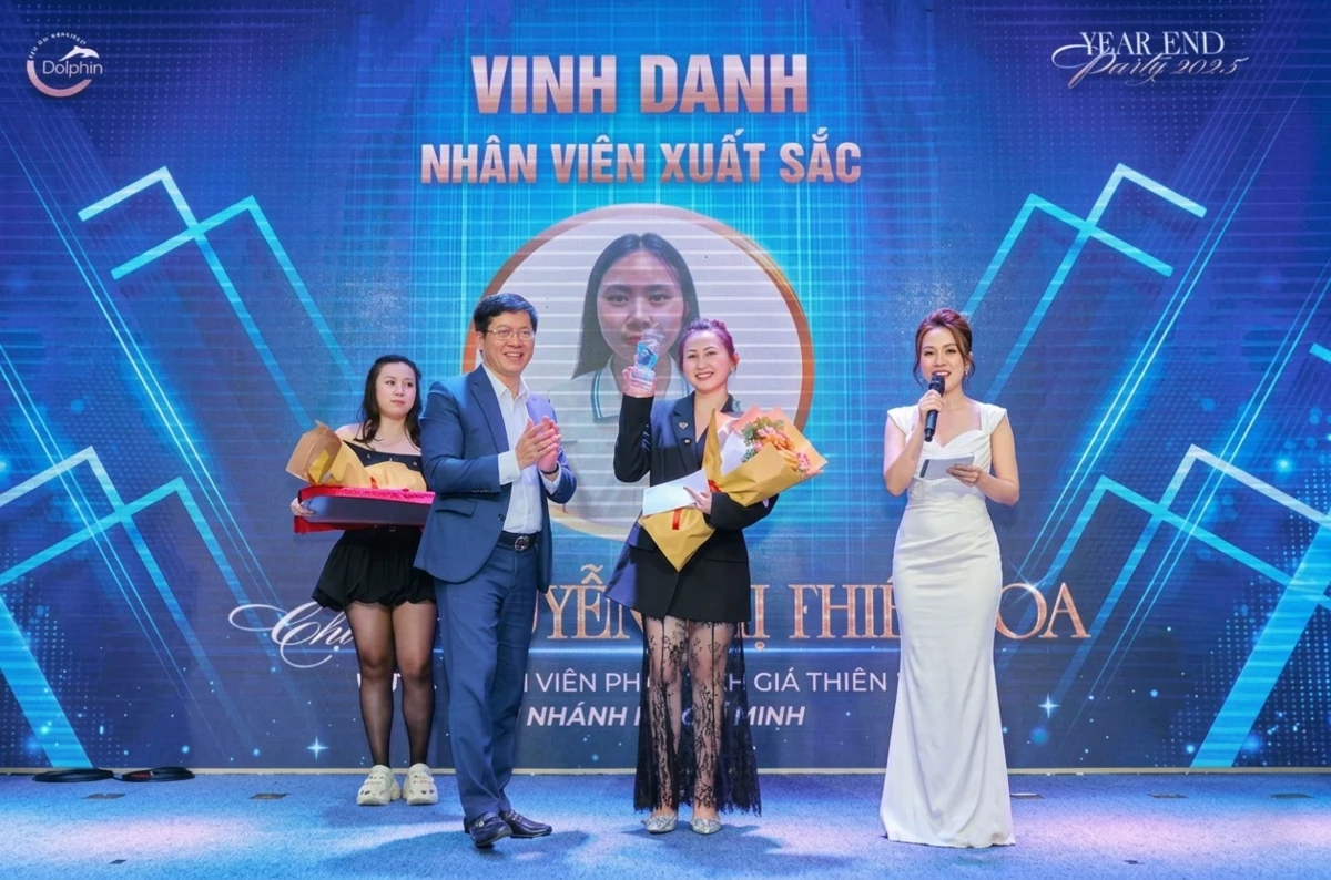 MC dẫn phần vinh danh nhân viên xuất sắc trong tiệc tất niên với người được vinh danh đứng nhận giải