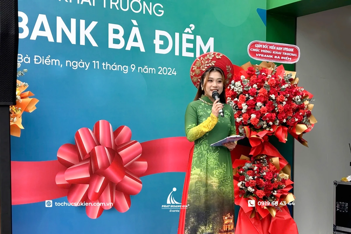 Nữ mc dẫn chương trình duyên dáng trong tà áo dài xanh tại lễ khai trương ngân hàng VPBank Bà Điểm