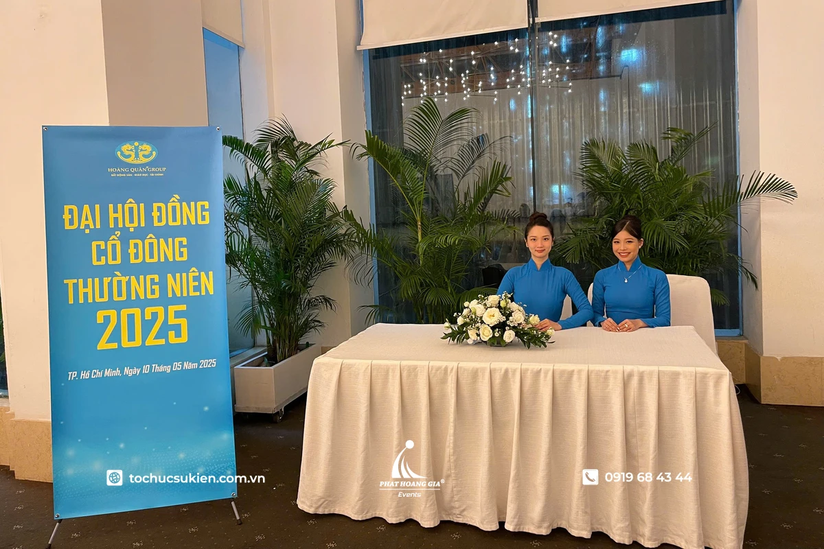 PG nữ ngôi tại khu vực sảnh hội nghị, hỗ trợ đón khách và tiếp nhận thông tin check-in trước khi vào sự kiện