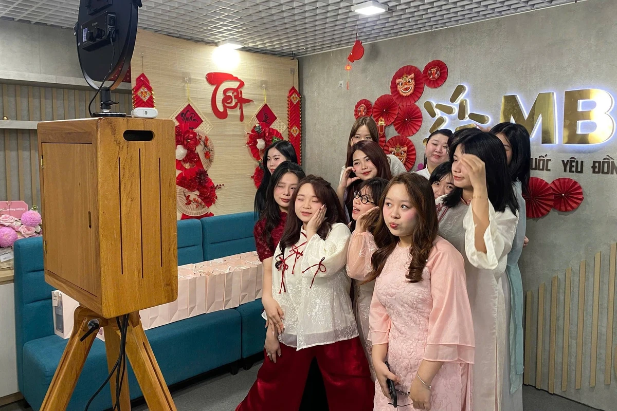Khu vực photobooth Tết được trang trí rực rỡ tại văn phòng, nơi nhân viên diện áo dài truyền thống nhiều màu sắc và lưu giữ những khoảnh khắc đầu xuân cùng đồng nghiệp