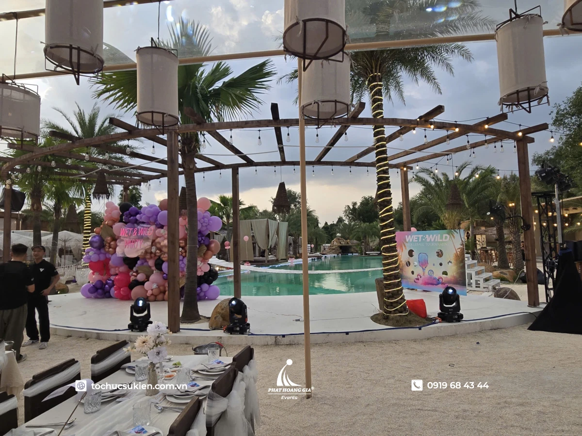 Không gian trang trí sự kiện pool party ngoài trời với backdrop bong bóng nổi bật cạnh hồ bơi xanh mát