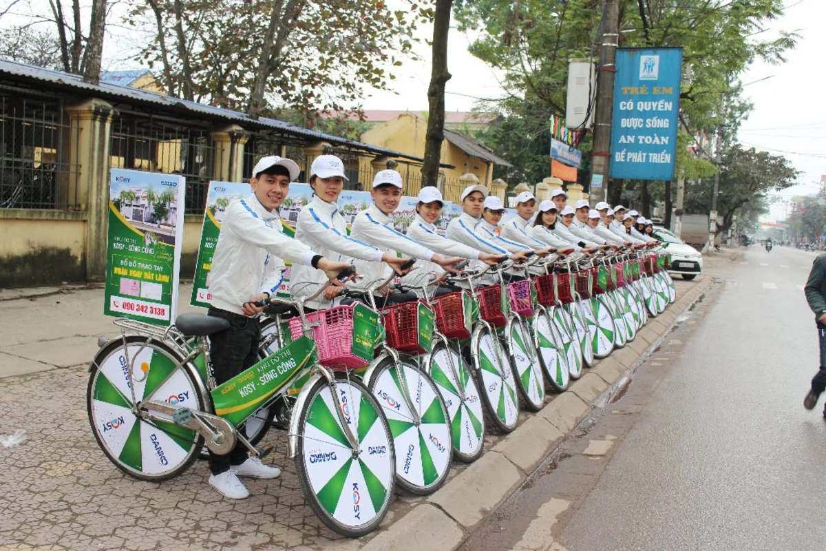 Đội hình roadshow xe đạp mặc đồng phục trắng xanh diễu hành quảng bá dự án.