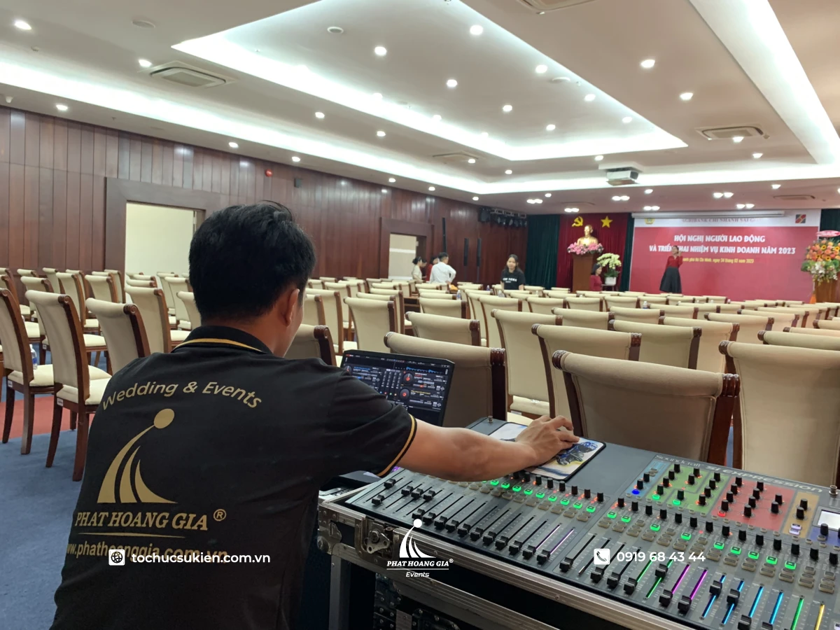 Kỹ thuật viên Phát Hoàng Gia điều chỉnh âm thanh ánh sáng phục vụ sự kiện bên trong sảnh hội nghị