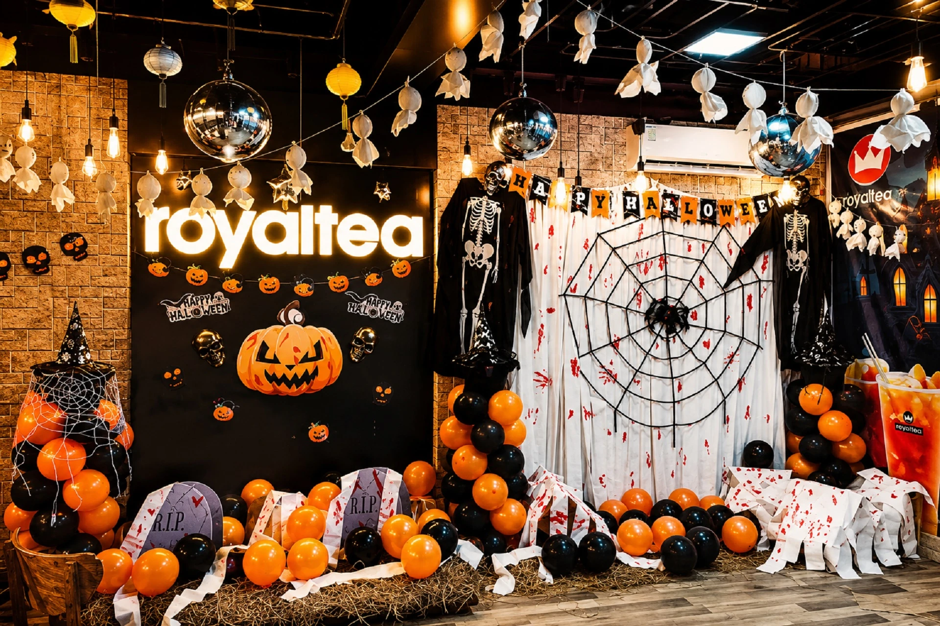 Không gian decor Halloween trong văn phòng với bí ngô, mạng nhện giả, bia mộ và bóng bay theo chủ đề lễ hội