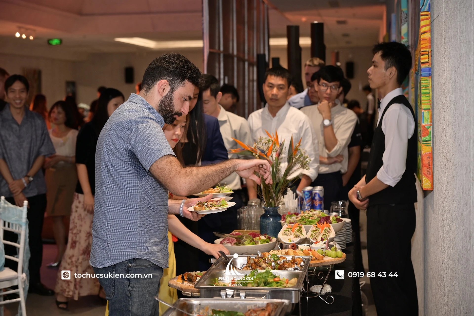 Toàn cảnh khách mời lựa chọn món ăn tại quầy buffet tất niên doanh nghiệp trong không gian khách sạn sang trọng