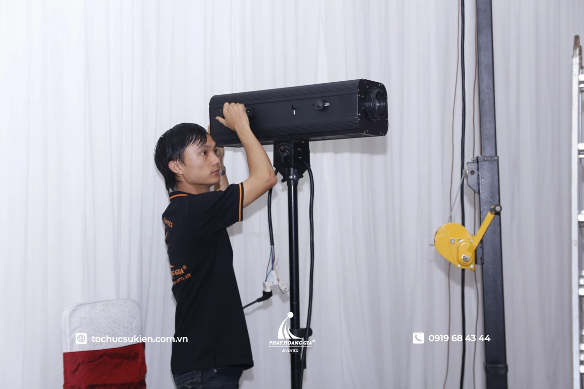 Hình ảnh kỹ thuật viên PHG vận hành đèn follow tại sự kiện.