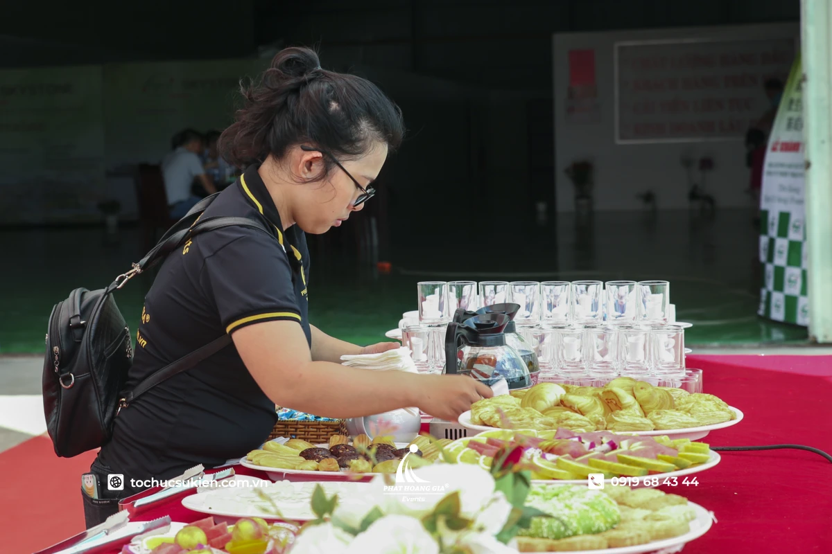 Nhân viên PHG chuẩn bị bàn tiệc buffet bánh ngọt sự kiện doanh nghiệp chuẩn bị đón khách