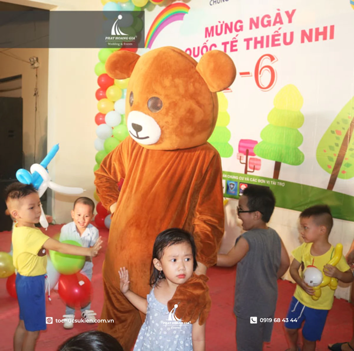 Mascot gấu đang chụp ảnh cùng các trẻ em trong ngày quốc tế thiếu nhi