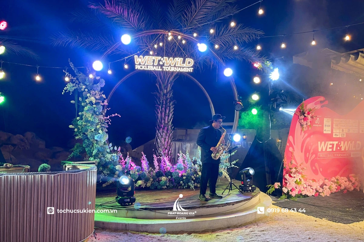 Biểu diễn saxophone đêm tiệc trước background kết hoa tươi cùng ánh đèn bắt mắt