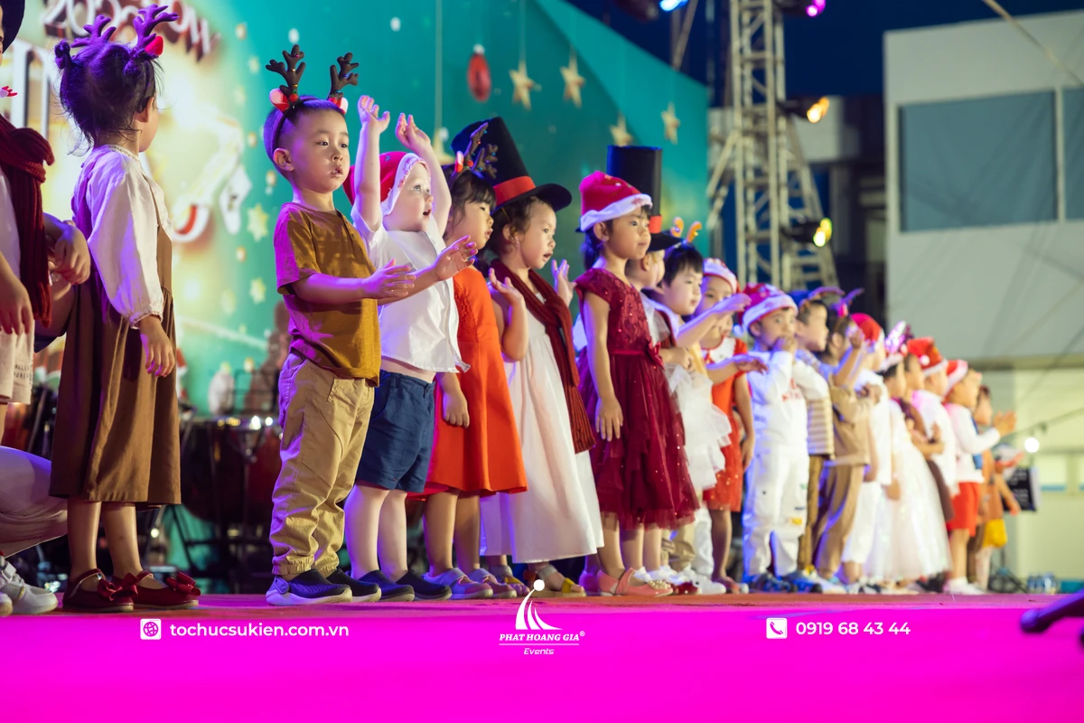 Các em nhỏ tham gia trò chơi noel trên sân khấu với trang phục và phụ kiện đầy màu sắc