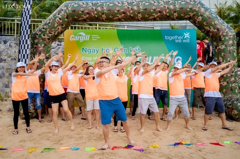Các thành viên tham gia nhảy múa theo nhịp điệu âm nhạc trong hoạt động team building trên bãi biển